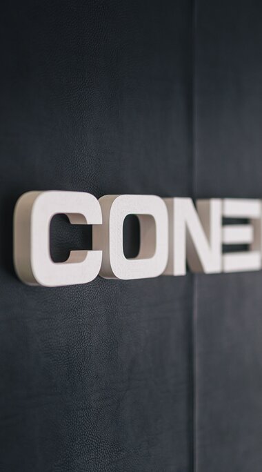 Firmenlogo von Conecto auf einer dunklen Wand | © Johannes Radlwimmer